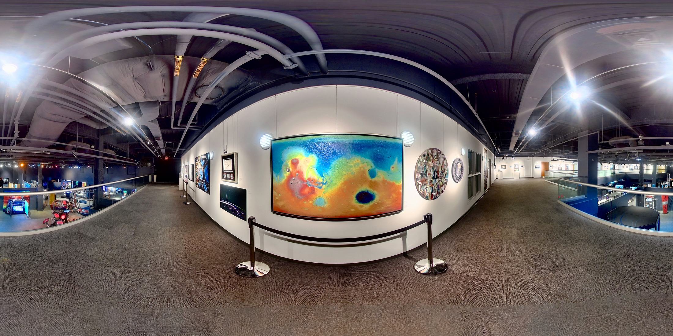 Panoramic view of science-based artwork displayed in a museum gallery.